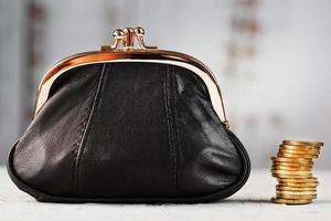 Black wallet with coins on a blue background. Budget for investment in the future. photo