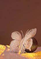 Shiny white butterfly on silver ball with sparkles and lanterns. Christmas, New Year, birthday, international women's day. Copy space photo