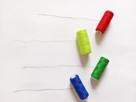 multi-colored threads for sewing on a white background photo