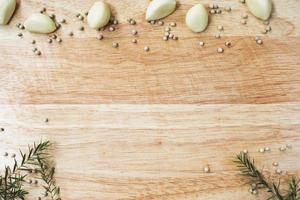 Garlic with pepper and rosemary place on wooden cutting board background, Food ingredients background, Spices and herb prepare for cooking, Kitchen and dining concept, photo