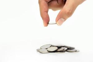 Man hand holding coin with A pile of coins on isolated white background, Money growing concept and sustainable investment, Business success and financial concept, Banking and economy idea photo