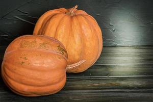 Two pumpkins on a black background. Halloween theme. photo