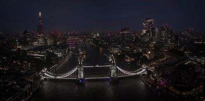 Aerial view to the illuminated Tower Bridge and skyline of London, UK photo