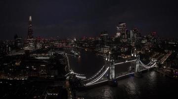 Aerial view to the illuminated Tower Bridge and skyline of London, UK photo