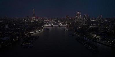 Aerial view to the illuminated Tower Bridge and skyline of London, UK photo