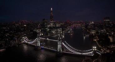 Aerial view to the illuminated Tower Bridge and skyline of London, UK photo