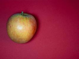 gran manzana roja sobre un fondo morado. el producto está sobre la mesa. frutas maduras frescas. foto