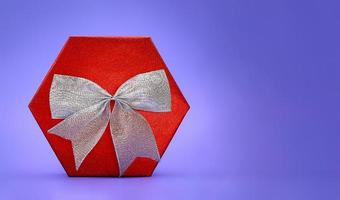 Big shiny red box with silver bow on lilac background. Present. Christmas, New Year, Mother's , Father's , International Women's Day, March 8, Birthday, Valentine. Copy space photo