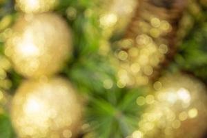 Abstract blurred shiny yellow Christmas balls and cone with barks and pine branches. New year card. Background photo