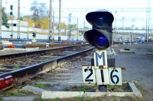 semáforo con luz azul ardiente. la intersección de las vías del tren foto