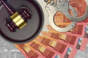 10 euro bills and judge hammer with police handcuffs on court desk. Concept of judicial trial or bribery. Tax avoidance photo