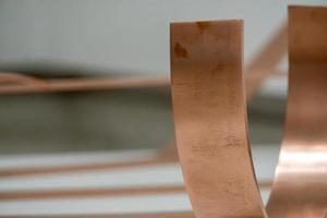 copper profiles of different dimensions on white background, polished copper reflecting light photo