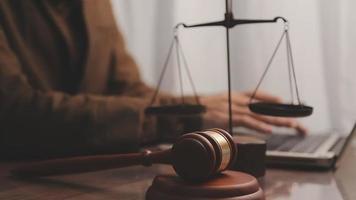 Justice and law concept.Male judge in a courtroom with the gavel, working with, computer and docking keyboard, eyeglasses, on table in morning light video