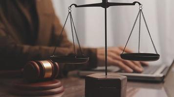Justice and law concept.Male judge in a courtroom with the gavel, working with, computer and docking keyboard, eyeglasses, on table in morning light video