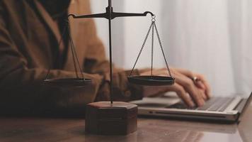 Justice and law concept.Male judge in a courtroom with the gavel, working with, computer and docking keyboard, eyeglasses, on table in morning light video