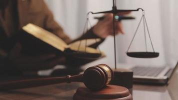 Justice and law concept.Male judge in a courtroom with the gavel, working with, computer and docking keyboard, eyeglasses, on table in morning light video