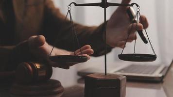 Justice and law concept.Male judge in a courtroom with the gavel, working with, computer and docking keyboard, eyeglasses, on table in morning light video