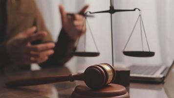 Justice and law concept.Male judge in a courtroom with the gavel, working with, computer and docking keyboard, eyeglasses, on table in morning light video