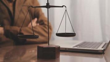 Justice and law concept.Male judge in a courtroom with the gavel, working with, computer and docking keyboard, eyeglasses, on table in morning light video