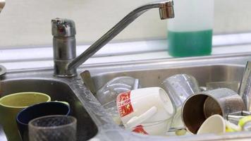 vaisselle sale dans la cuisine, déconnexions et interruptions de l'approvisionnement en eau, une hôtesse bâclée. video