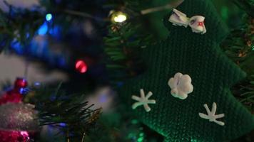 a garland flashes on an artificial Christmas tree decorated with toys and balloons. video