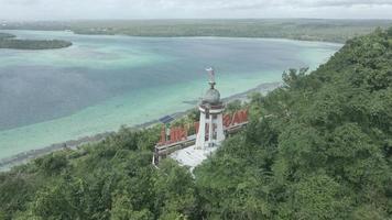 antenn se av Jesus staty med skön strand se i små ö. maluku, indonesien - juli, 2022 video