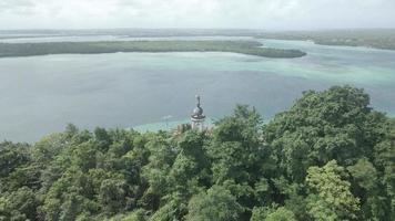 antenn se av Jesus staty med skön strand se i små ö. maluku, indonesien - juli, 2022 video