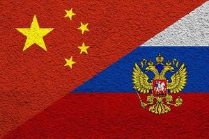 Contact between Russia and the People's Republic of China. Concept. Russia and China flag background on cement wall texture. photo