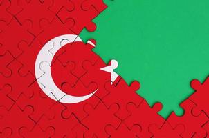 Turkey flag  is depicted on a completed jigsaw puzzle with free green copy space on the right side photo