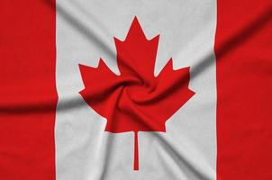 Canada flag  is depicted on a sports cloth fabric with many folds. Sport team banner photo