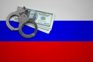 Russia flag  with handcuffs and a bundle of dollars. The concept of breaking the law and thieves crimes photo