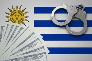 Uruguay flag  with handcuffs and a bundle of dollars. The concept of illegal banking operations in US currency photo