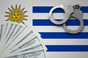 Uruguay flag  with handcuffs and a bundle of dollars. The concept of illegal banking operations in US currency photo