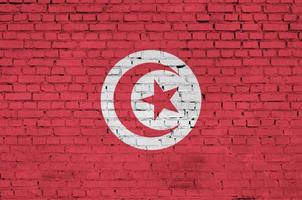 Tunisia flag is painted onto an old brick wall photo