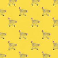 Shopping addiction, shopping lover or shopaholic concept. Many small empty shopping carts perform a pattern on a pastel colored paper background. Flat lay composition, top view photo