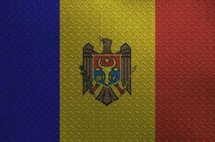 Moldova flag depicted in paint colors on old brushed metal plate or wall closeup. Textured banner on rough background photo