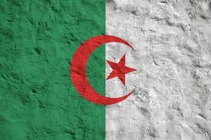 Algeria flag depicted in bright paint colors on old relief plastering wall. Textured banner on rough background photo