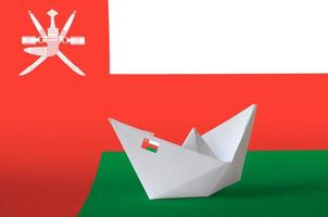 Oman flag depicted on paper origami ship closeup. Handmade arts concept photo