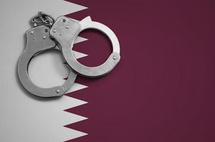 Qatar flag  and police handcuffs. The concept of crime and offenses in the country photo