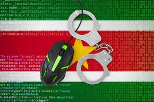 Suriname flag  and handcuffed computer mouse. Combating computer crime, hackers and piracy