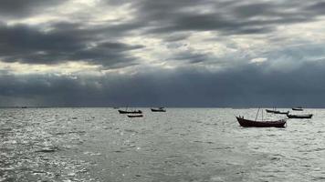 A fishing boat facing a rainstorm on a black cloud day. video