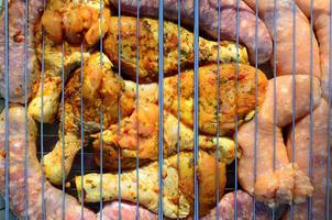 Marinated chicken legs on hot BBQ charcoal field grill photo