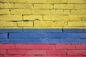 Colombia flag is painted onto an old brick wall photo