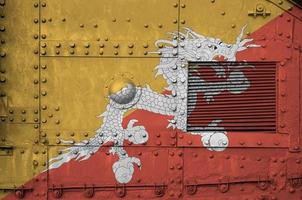 bandera de bhután representada en la parte lateral del primer plano del tanque blindado militar. antecedentes conceptuales de las fuerzas armadas foto