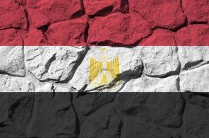 Egypt flag depicted in paint colors on old stone wall closeup. Textured banner on rock wall background photo