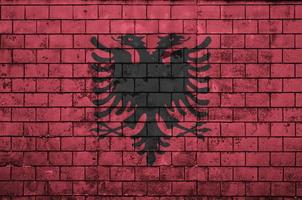 Albania flag is painted onto an old brick wall photo