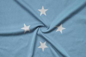 la bandera de micronesia está representada en una tela deportiva con muchos pliegues. bandera del equipo deportivo foto