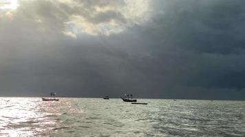 un' pesca barca di fronte un' temporale su un' nero nube giorno. video