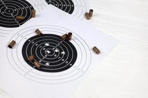 muchas balas en objetivos de tiro en la mesa blanca en el polígono de campo de tiro. entrenamiento para apuntar y disparar foto