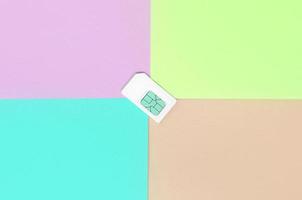 Subscriber identity module. White SIM card on pastel background photo